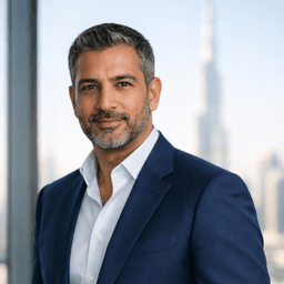 Professional Middle Eastern man in navy suit with confident smile in modern office